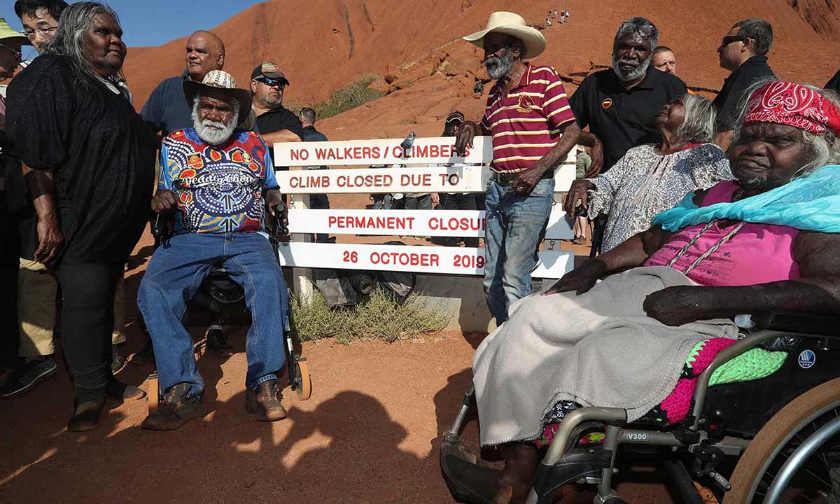 People stand at a sign saying the Climb is closed.