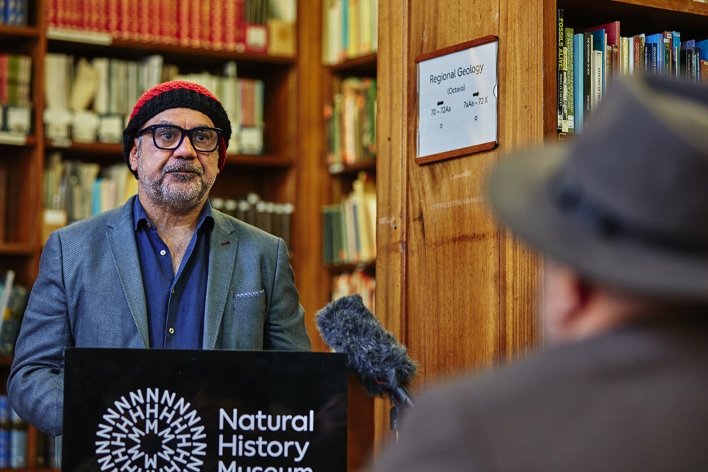 a man stands behind a podium in a library
