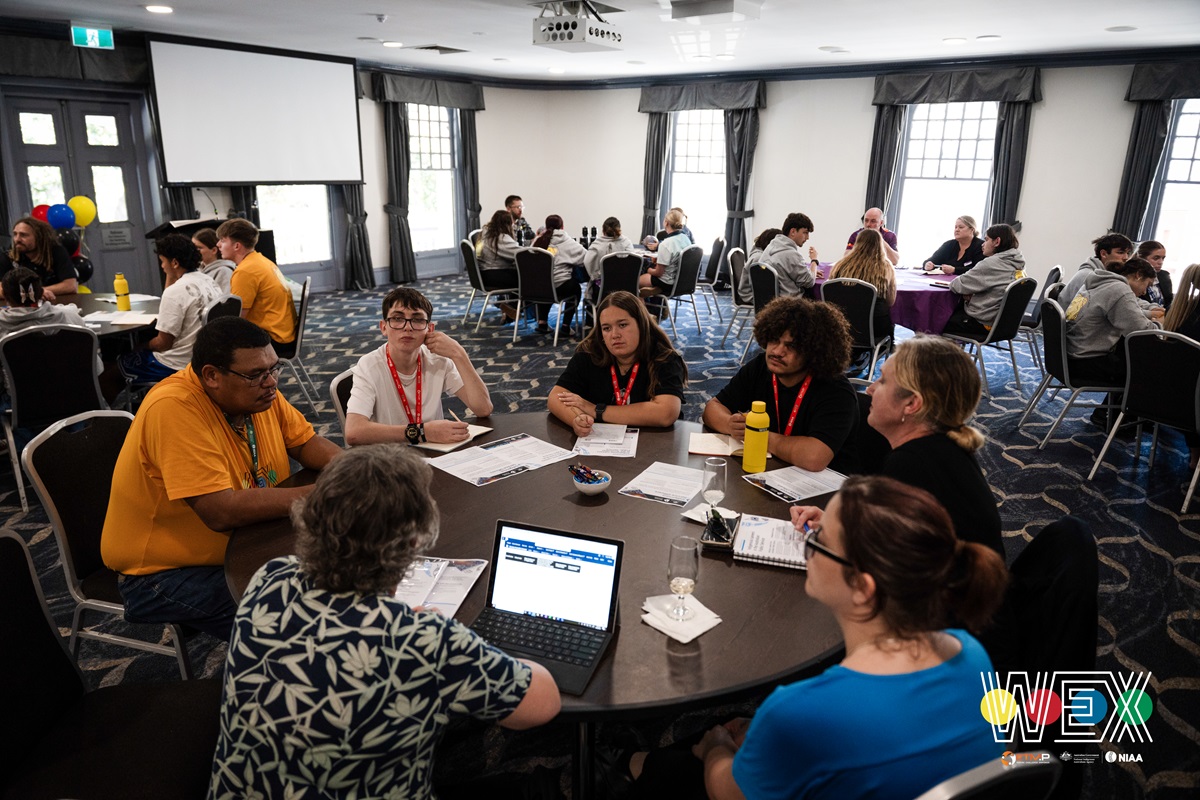 a group of students and teachers sit at a round table