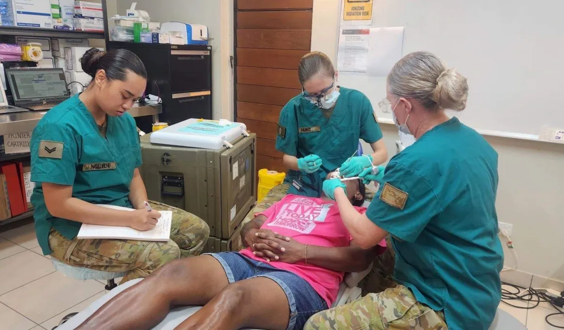 Three army dentists working on a patient