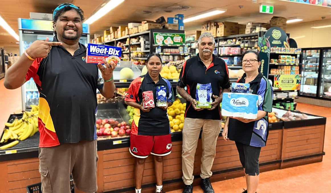 People hold common items up in a supermarket