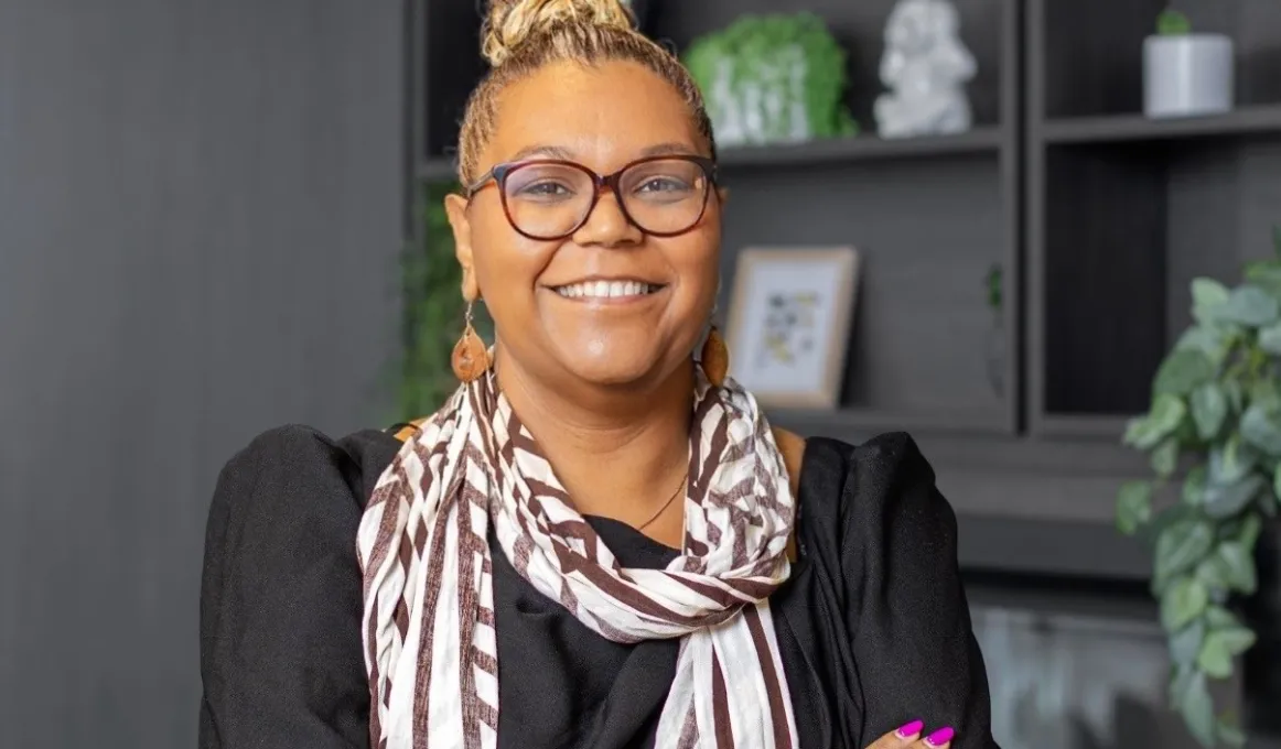 A lady smiles proudly in an office