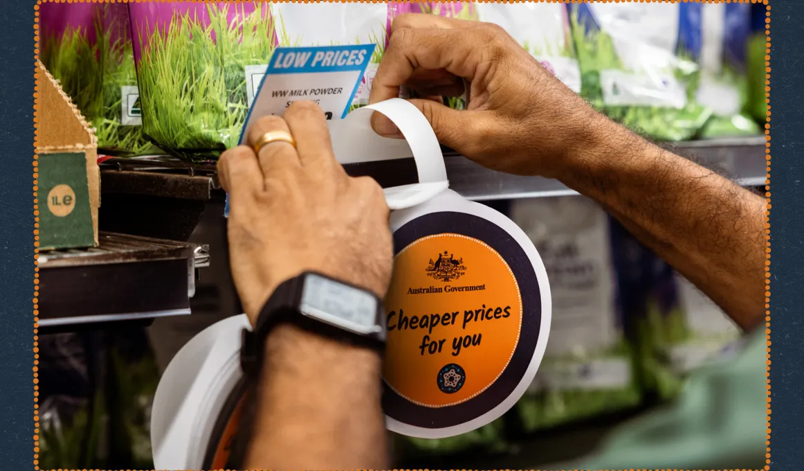 Hands putting a Cheaper prices for you wobbly sign on a store shelf