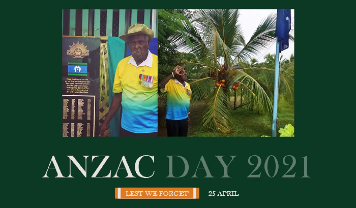 At right, an elderly man wearing a yellow and blue shirt and kaki hat salutes a blue flag on a flagpole. At left, the same man stands next to a memorial with names engraved on it.