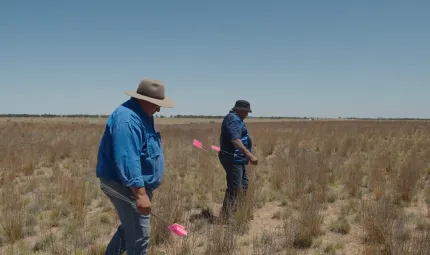 Two men walk across a dry lake bed