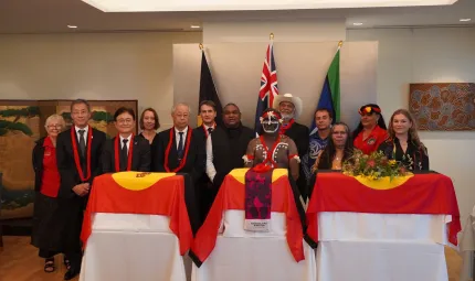 Members stand together behind 3 tables with special containers
