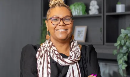 A lady smiles proudly in an office