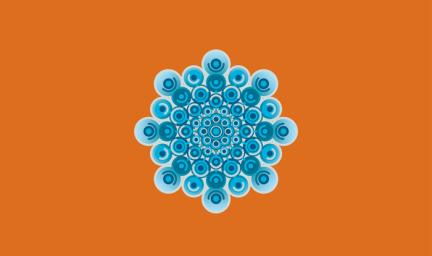 A selection of blue dots in varying shade of blue in the shape of a snowflake on an orange background.